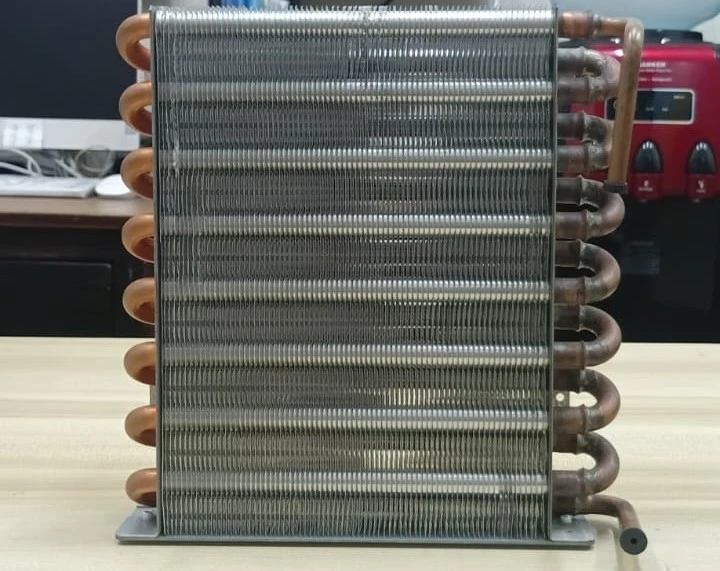 fungsi kondensor adalah menurunkan panas gas refrigeran dari proses kompresi pada kompresor dengan mengalirkan suhu tersebut pada kisi-kisi dan koil panjang.